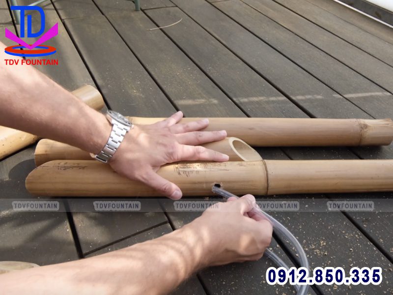 Luồn ống nhựa dẫn nước vào ống tre